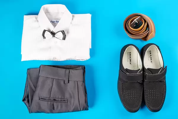 Male classic clothing on blue, top view - shirt, trousers, shoes and belt, top view