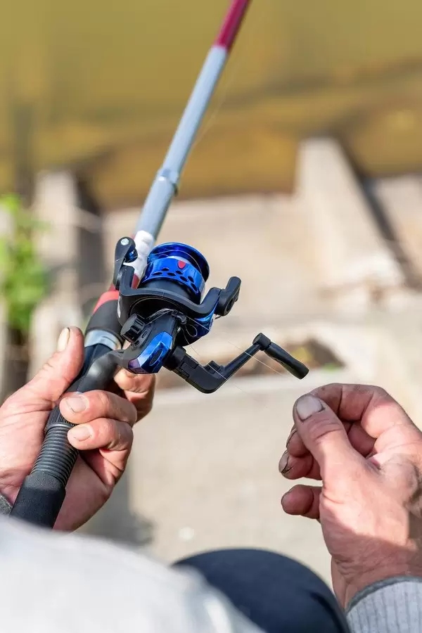 Male hand with a spinning rod in his hands. The concept of fishing