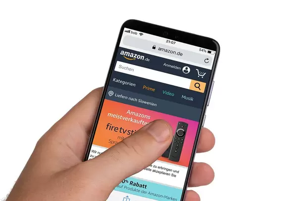 Male hands holding smartphone with an open Amazon website