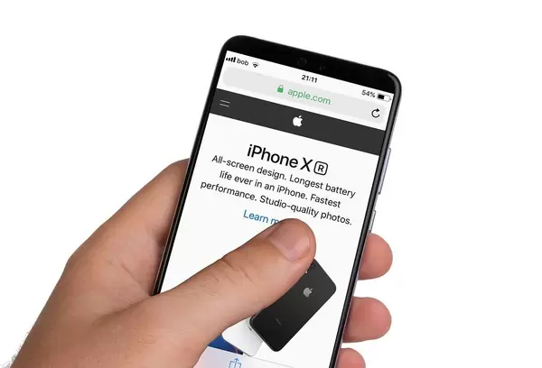 Male hands holding smartphone with an open Apple website