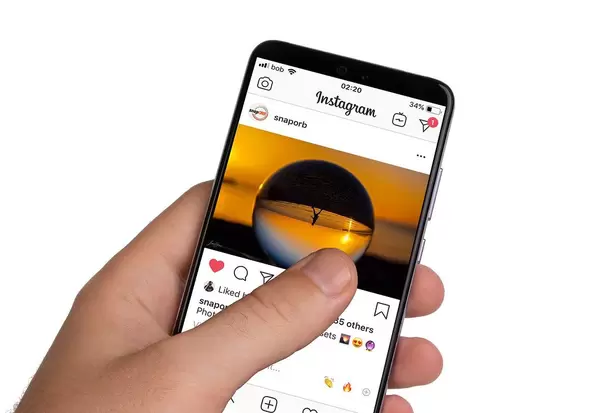 Male hands holding smartphone with an open Instagram application