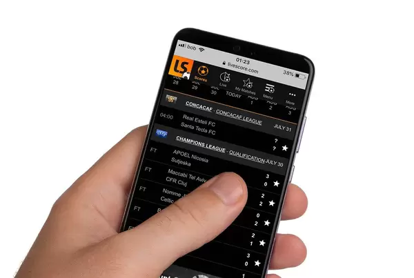 Male hands holding smartphone with an open Livescore application