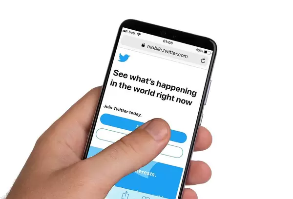 Male hands holding smartphone with an open Twitter application