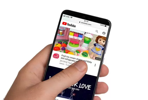 Male hands holding smartphone with an open YouTube application