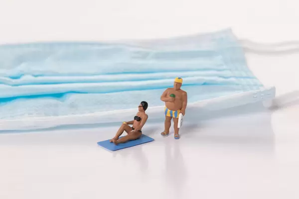 Man and woman in bath suit with medical face mask