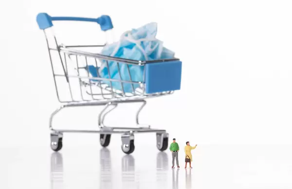 Man and woman stading in front of shopping cart with used medical face mask