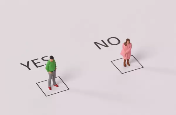 Man and woman standing in a Yes and No checkboxes