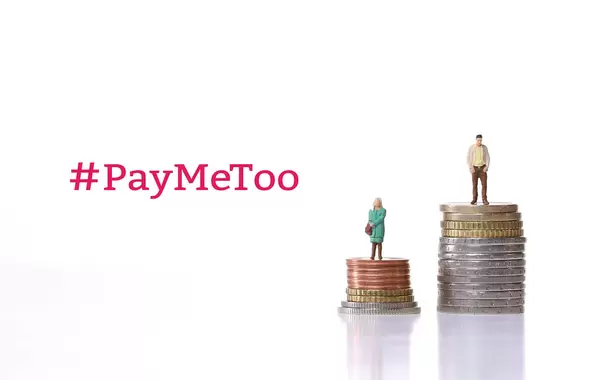 Man and woman standing on a stacks of coins with #PayMeToo text