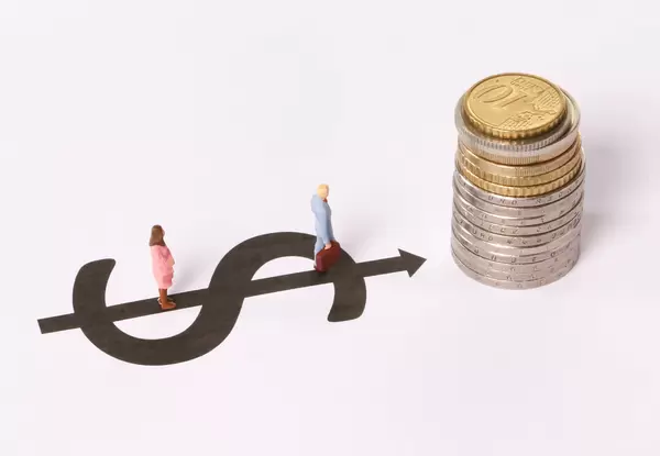 Man and Woman standing on dollar symbol pointing at stack of coins on white background