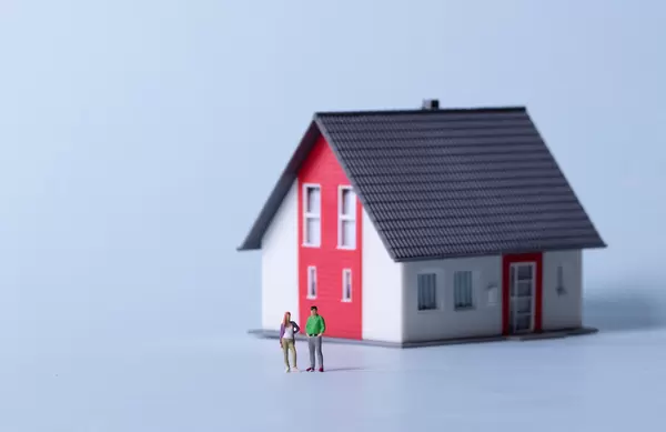 Man and woman with house on a light blue background