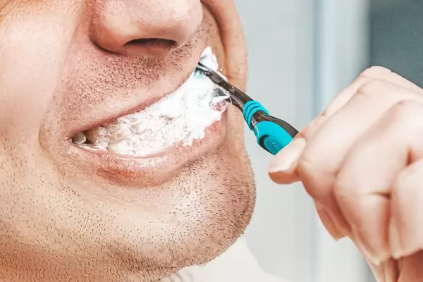Man brushing his teeth in bathroom (Flip 2019)