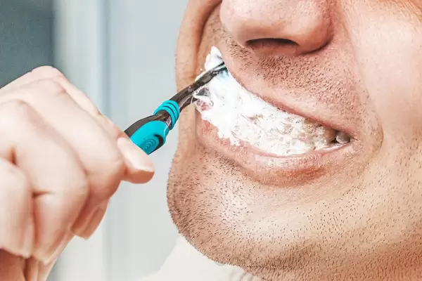 Man brushing his teeth in bathroom