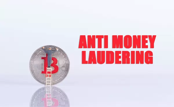 Man cleaning silver Bitcoin coin with Anti Money Laudering text