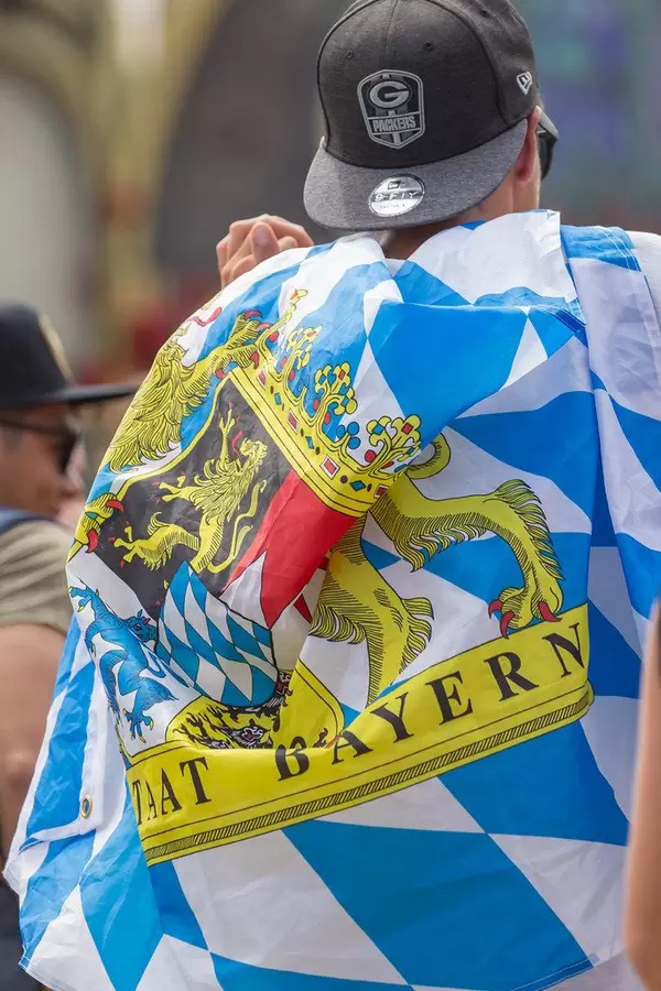 Man covered by a cloth with 'Free State of Bavaria' text dancing at Tomorrowland festival