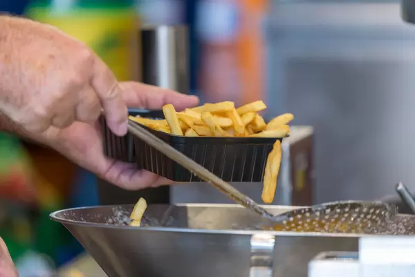 Man filling a plastic box with french fries