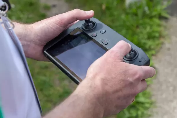 Man hold a DJI Mavic 2 Smart Controller with 5.5-inch screen and automatic connection to the drone