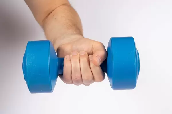 Man holding blue dumbbell isolated on white