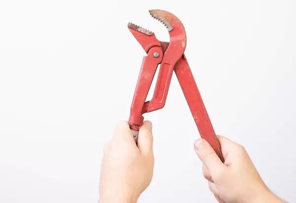 Man holding plumbers wrench (Flip 2019)