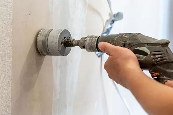 Man holds a tool for sanding a wall