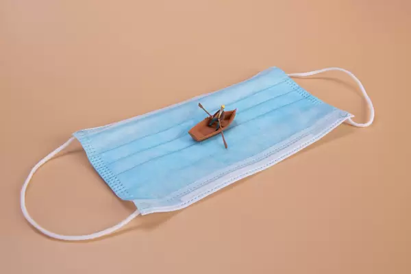 Man in a boat on a blue medical face mask