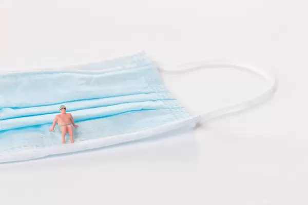 Man in bath suit on medical face mask