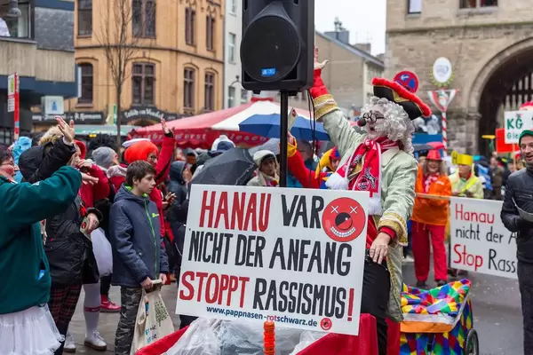 Man in carnival costume states "stop racism" at Shrove Monday procession in Cologne