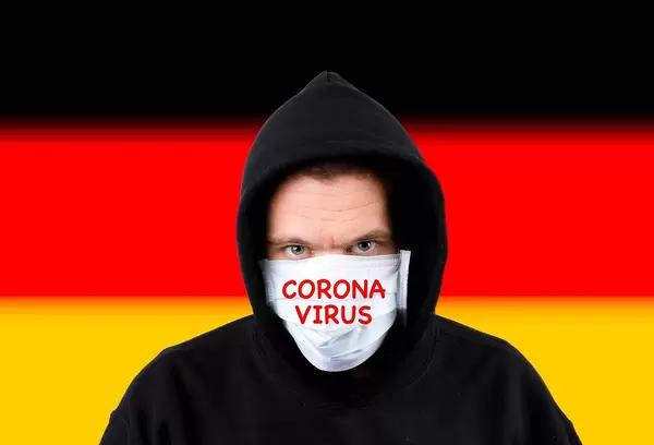 Man in hoodie wearing protection face mask with flag of Germany