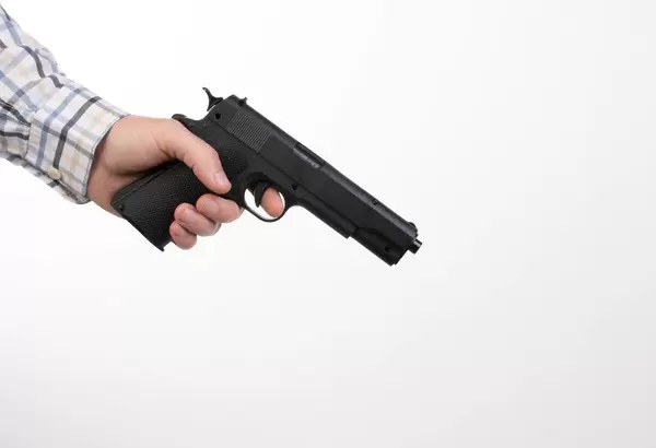 Man in shirt holding a gun