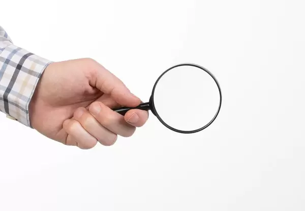Man in shirt holding magnifying glass