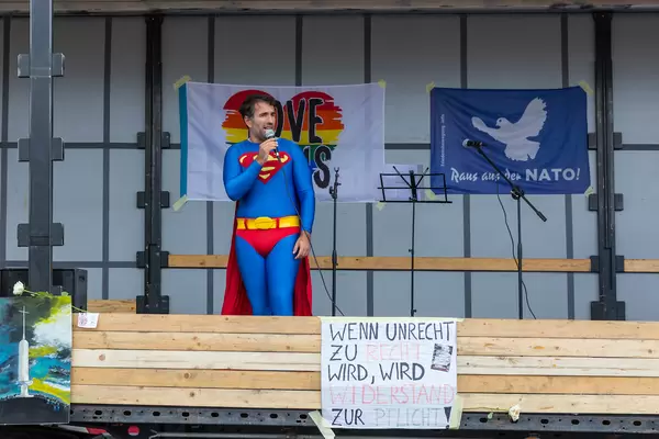 Man in Superman costume holds a speech from the stage of the anti-Covid demo in Cologne
