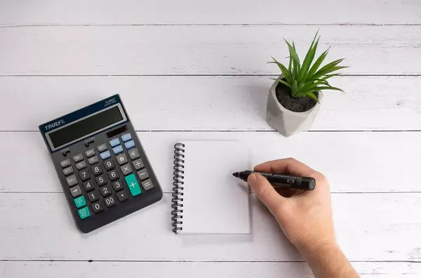 Man making a note on white wooden table