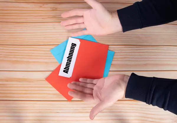 Man opens red envelope with Abmahnung text
