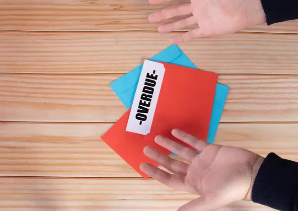 Man opens red envelope with Overdue text