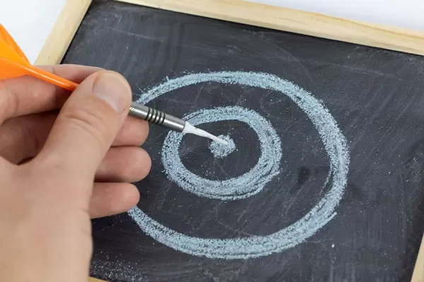 Man pointing in center with dart