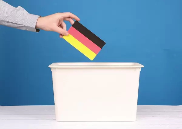 Man putting his vote in the ballot box at German elections.jpg