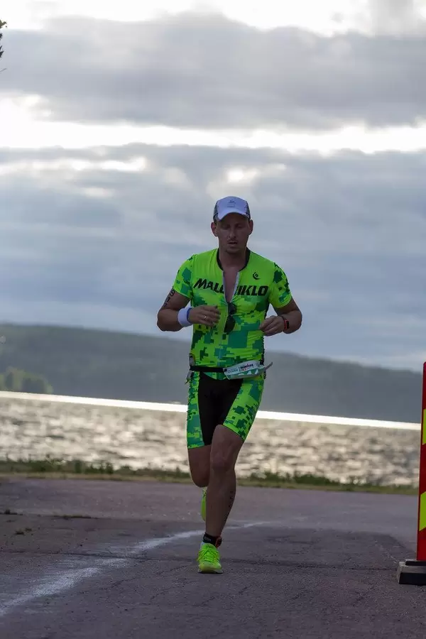 Man runs the marathon as part of the triathlon competition Ironman 70.3 on the coast of Lahti, Finland