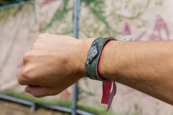 Man shows the Tomorrowland festival bracelet on his hand with the logo of the festival on it