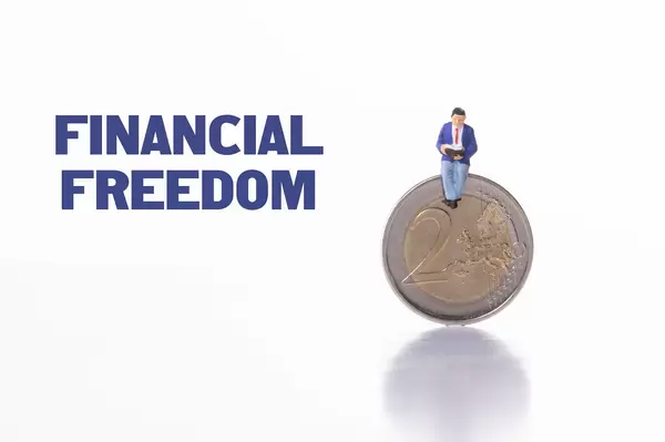 Man sitting on 2 Euro coin with Financial Freedom text