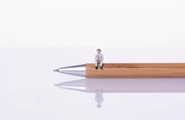 Man sitting on a wooden pen with white bakground