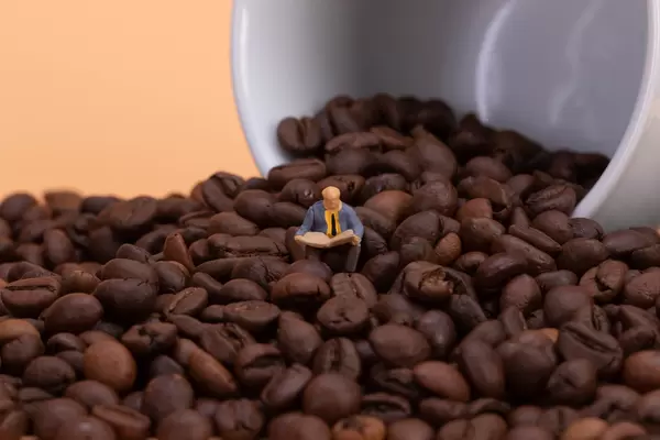 Man sitting on coffee beand and reading newspaper