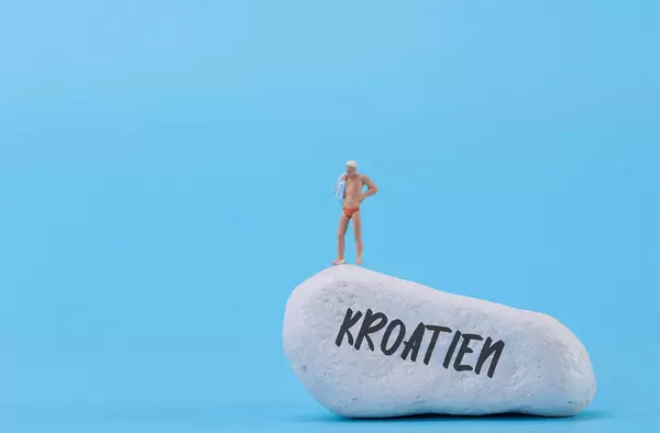 Man standing at the rock with Kroatien text
