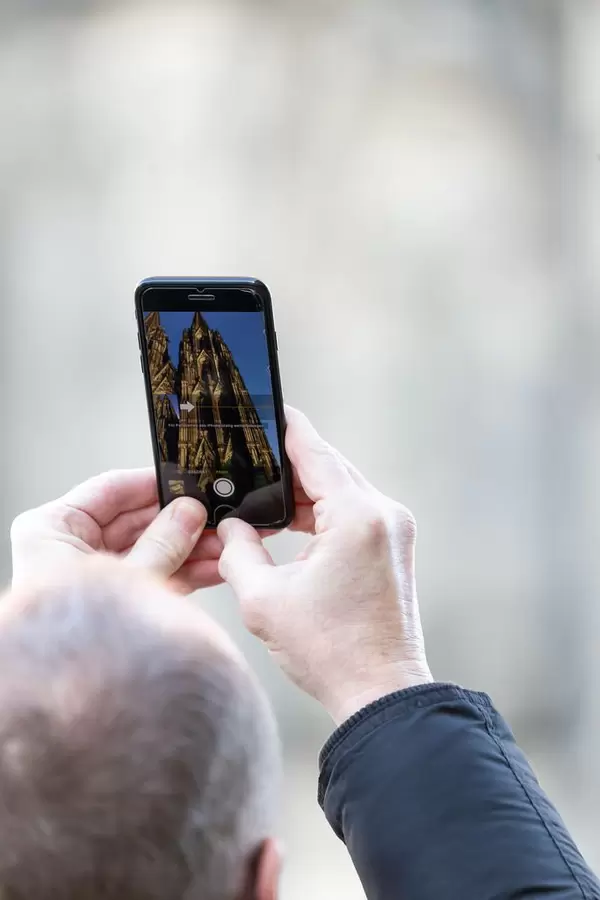 Man taking photos of Cologne Cathedral with his iPhone