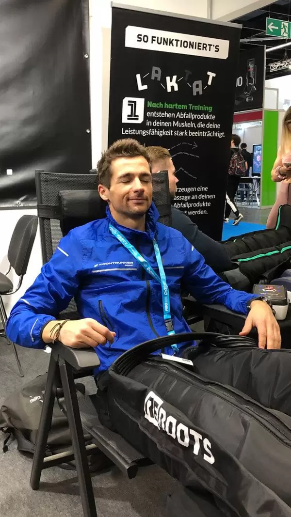 Man tests the Reboots Go Recovery Boots recommended for warm-up, relaxation or directly after training at Fibo in Cologne