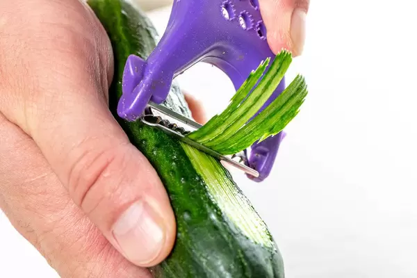Man thin slices cucumber closeup (Flip 2019)