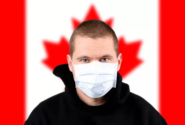 Man wearing protection face mask with flag of Canada
