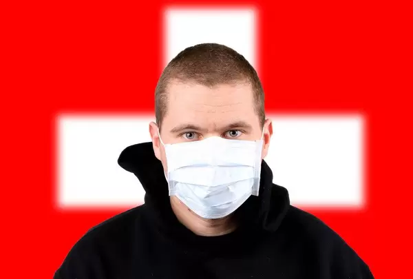 Man wearing protection face mask with flag of Switzerland