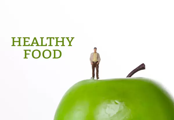 Man with green apple and Healthy Food text