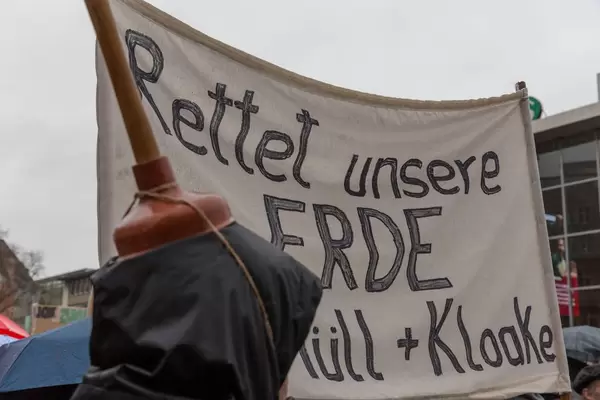 Man with toilet brush on his head protests against global warming