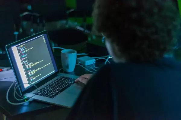 Man working from home office on a notebook in a dark room