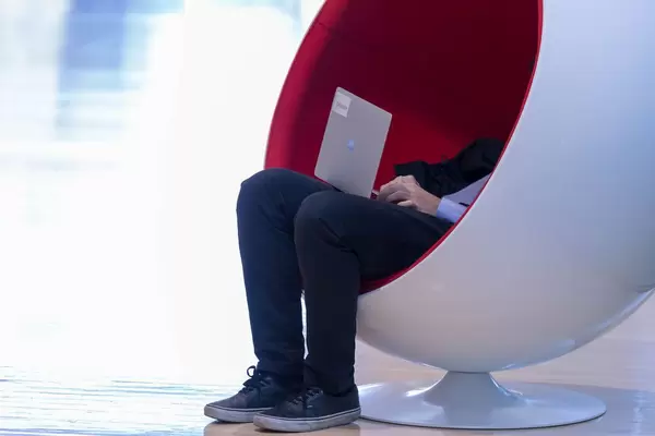 Man working on laptop in designer-chair